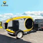Compact yellow and grey teardrop mini caravan CODE 2604 hitched to SUV, external kitchen, rooftop skylight, off-road chassis