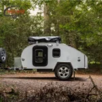 WECARE Basic Teardrop Mini Off-Road Camper Trailer parked in a scenic forest setting for off-grid adventure travel.