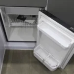 Open 50L fridge freezer inside the Black Betty Skadoo off-road camper trailer showing internal storage shelving.
