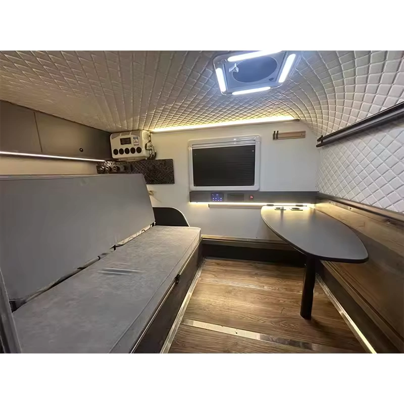 Cindy Cinema mini caravan interior with queen bed, foldable table, LED mood lights and quilted walls for off-grid camping