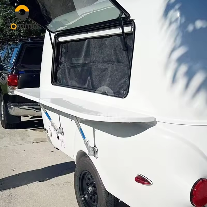 Eezon Eddy midsize caravan features an exterior fold-out kitchen shelf and awning setup for off-grid camping adventures.