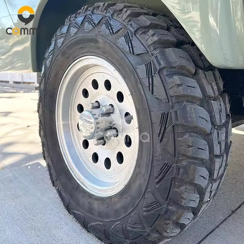Heavy-duty off-road tire and wheel assembly on the Eezon Eddy midsize camper caravan for all-terrain adventures.