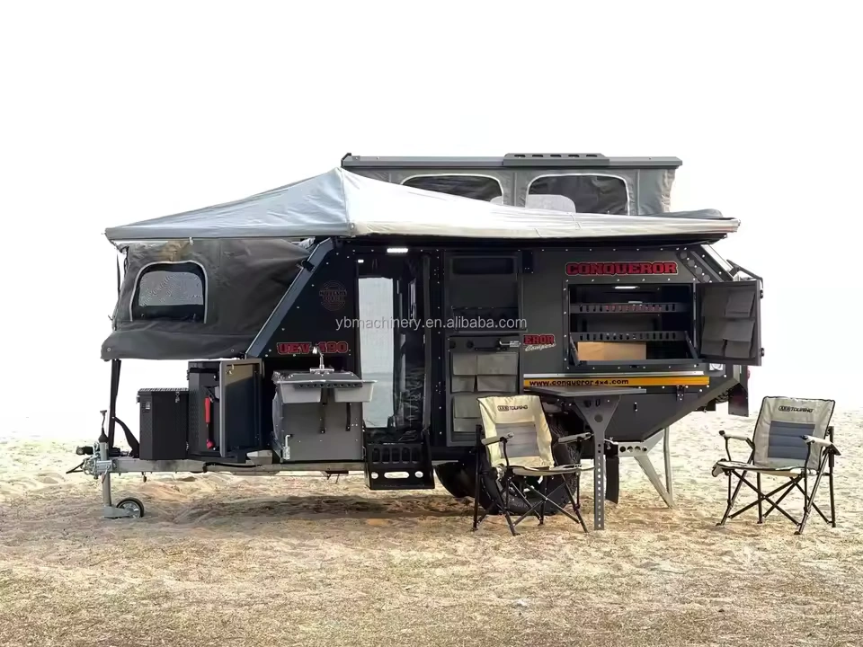 Gutsy Gary off-road camper trailer parked on sand with awning, slide-out stainless steel outdoor kitchen and camping chairs