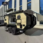 The Lucy Lux Black Rhino-2A hybrid caravan features an expandable outdoor kitchen, rugged off-road tires, and setup.