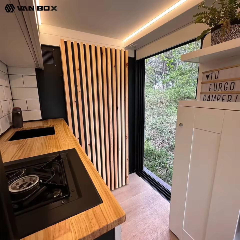 Van Box campervan interior with wooden countertop, gas hob, sink and open sliding door to forest, Van Conversion CODE 2603