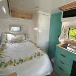 Molly Moulds midsize caravan interior featuring queen bed with lemon design bedding and teal kitchenette drawers