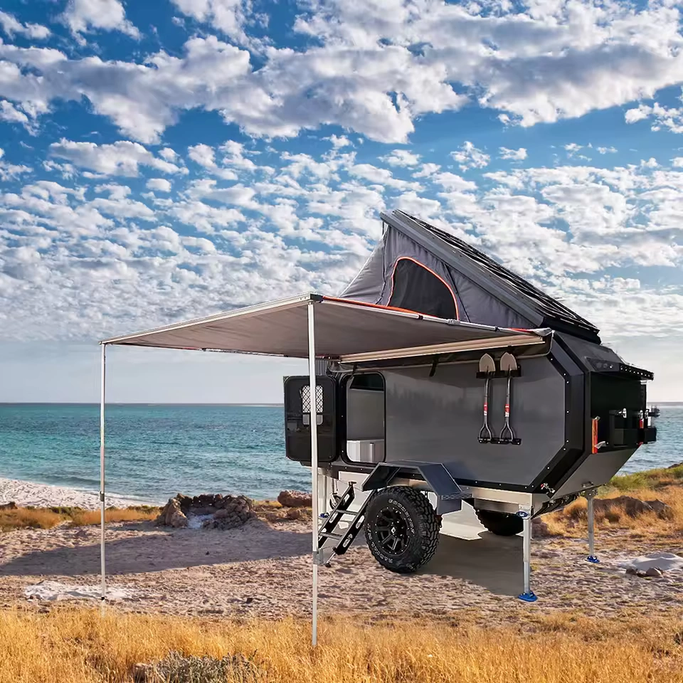 Offroad Olly RTT camper trailer with rooftop tent and awning parked at the beach for off-grid camping adventures.