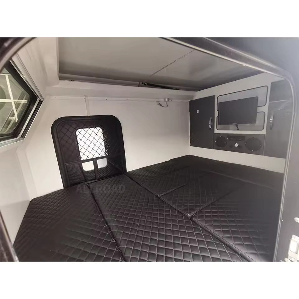 Modern interior of the Offroad Olly RTT camper trailer featuring a plush queen-sized quilted bed and integrated TV.