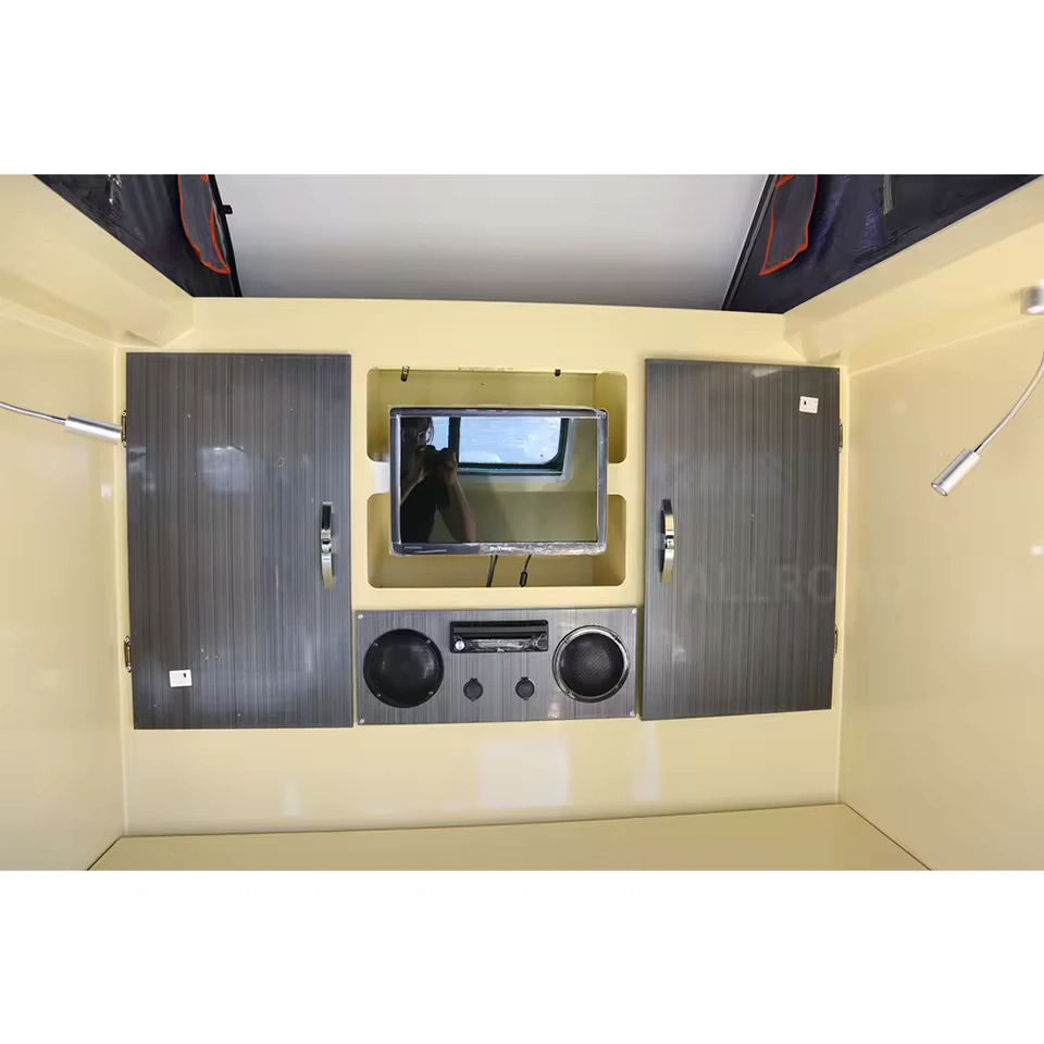 Premium interior entertainment setup in the Offroad Olly RTT caravan featuring a TV, audio system, and storage cabinets.