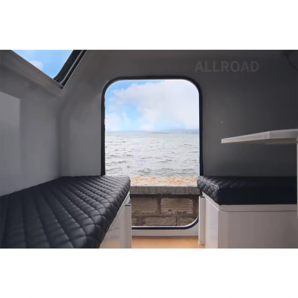 Interior view of the Offroad Olly RTT camper trailer featuring comfortable sleeping benches and a scenic water view.
