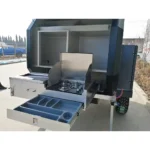 Offroad Olly RTT camper trailer features a slide-out stainless steel outdoor kitchen with a stove and storage drawer.