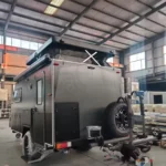 Popup Poppy off-road mini caravan in factory with pop-top roof, spare wheel, awning and hot-dipped galvanised chassis