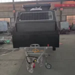 Popup Poppy off-road mini caravan front shot showing rooftop solar, heavy-duty chassis, tow hitch and storage box in workshop