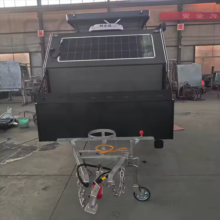 Popup Poppy off-road mini caravan front shot showing rooftop solar, heavy-duty chassis, tow hitch and storage box in workshop