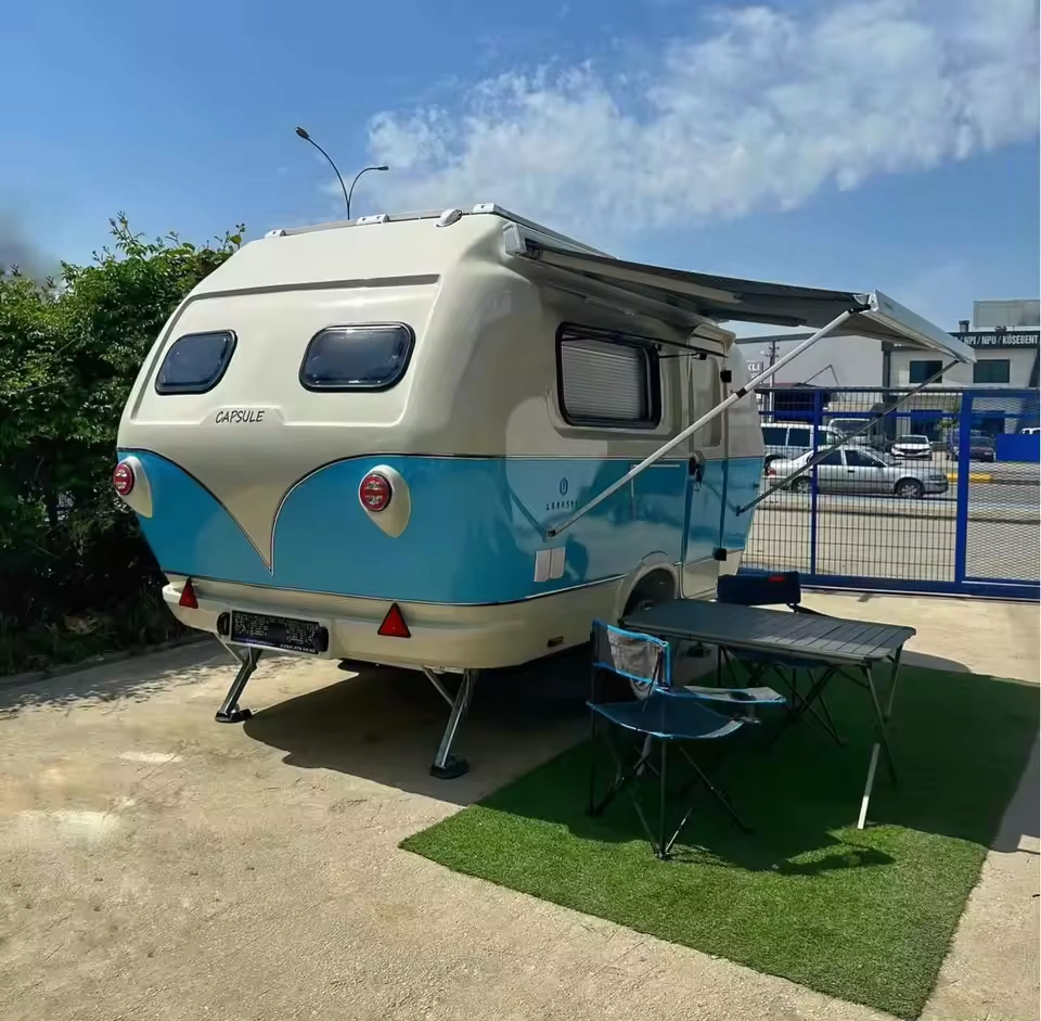 Retro blue-and-cream Capsule mini caravan with awning, table and chairs on artificial turf, Molly Moulds CODE 2610