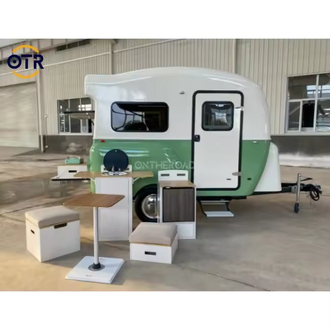 Retro Rex green-and-white teardrop camper trailer with outdoor kitchen, fold-out tables and storage for weekend getaways