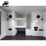 Modern white interior of the Shark I off-road camper trailer featuring built-in storage shelves and striped flooring.