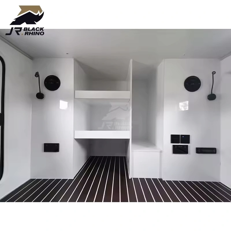Modern white interior of the Shark I off-road camper trailer featuring built-in storage shelves and striped flooring.