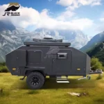 Shark I off-road mini camper trailer in matte black parked in a scenic mountain landscape for off-grid travel adventures.
