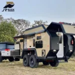 The Terminator Black Rhino-2A off-road hybrid caravan parked outdoors with its kitchen and storage compartments open.