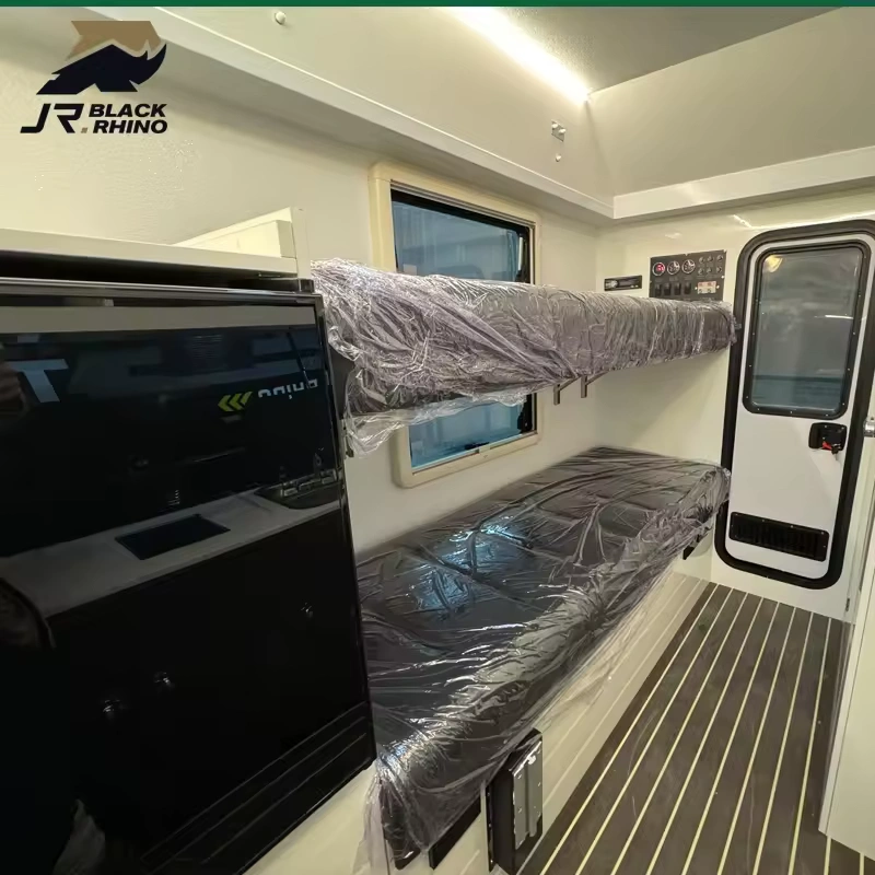 Interior view of the Black Rhino off-road caravan showing bunks with protective plastic and a sleek modern kitchen unit.
