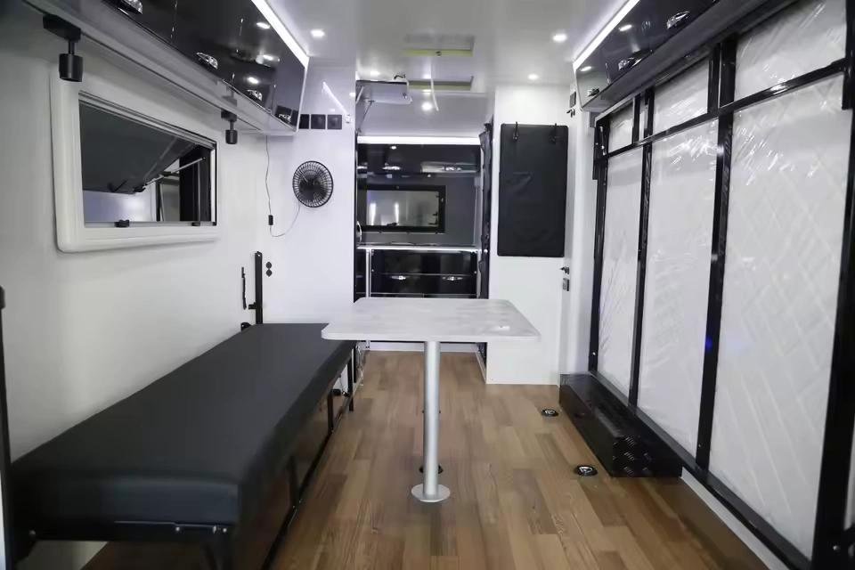 Modern interior view of the Toy Boy caravan featuring a convertible dining area, sleeping space, and premium finishes.