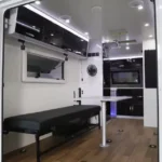 Modern interior view of the Toy Boy off-road toy hauler showing the comfortable dining area and bench seating setup.