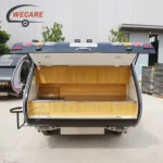 WECARE Mini Teardrop Camper with an open rear galley kitchen featuring stainless steel countertop and wooden cabinets.