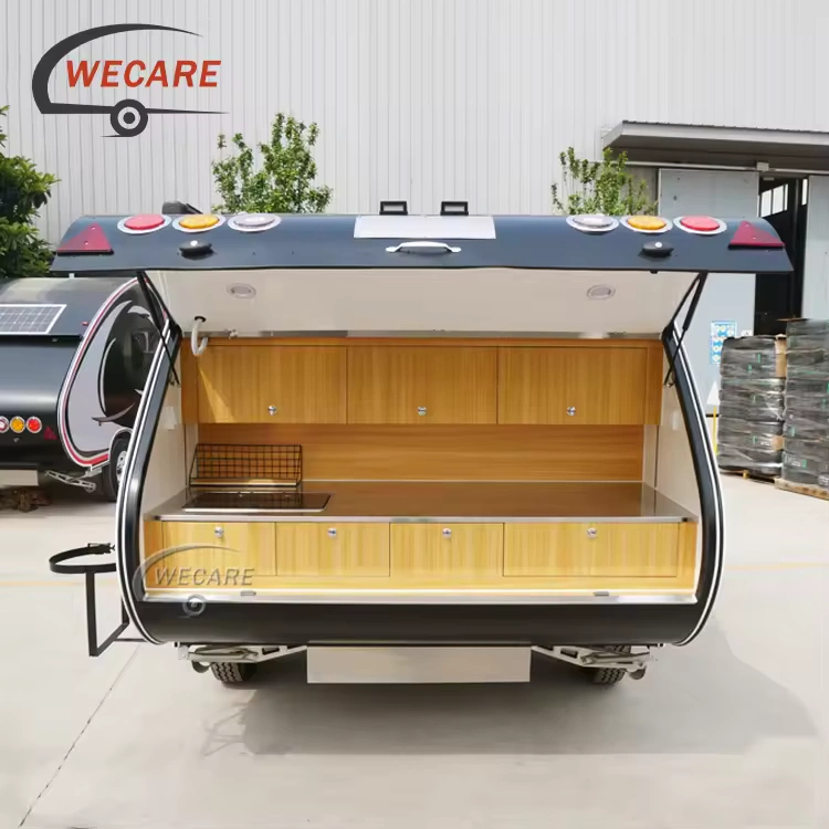 WECARE Mini Teardrop Camper with an open rear galley kitchen featuring stainless steel countertop and wooden cabinets.