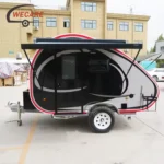 WECARE mini teardrop caravan with side awning, featuring a modern black and silver design, parked outdoors for display.