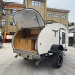 White offroad teardrop travel caravan with an open rear slide-out kitchen for sale at China Caravans