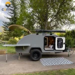 The Cody Compact mini caravan features a slide-out kitchen, rooftop awning, and an insulated aluminum body for camping.