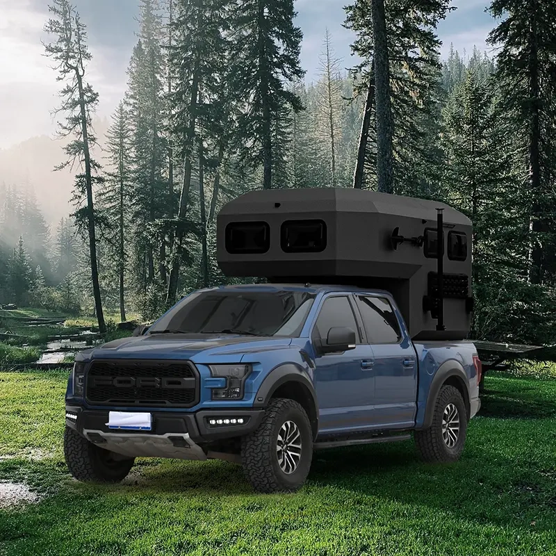 The Larry Light CODE 2685 off-road camper trailer mounted on a blue Ford truck in a scenic forest clearing for travel.