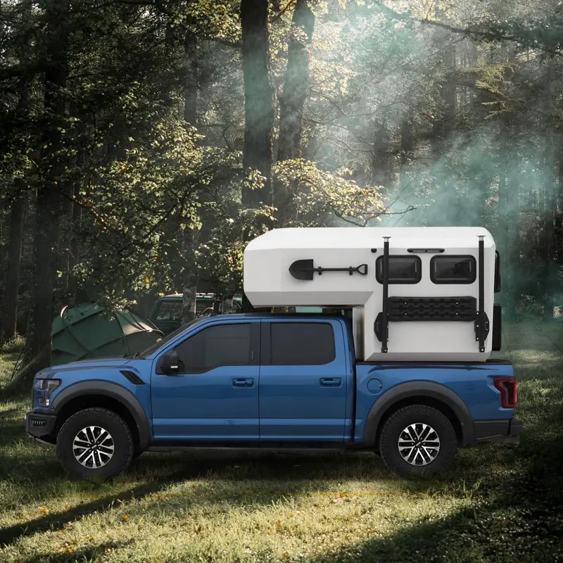 The Larry Light CODE 2685 slide-on camper mounted on a blue pickup truck parked in a scenic forest setting for camping.